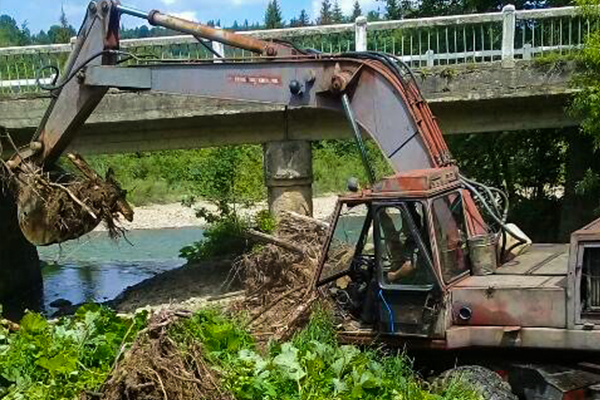 Дорожники розчищають русло річки під мостом у Розтоках